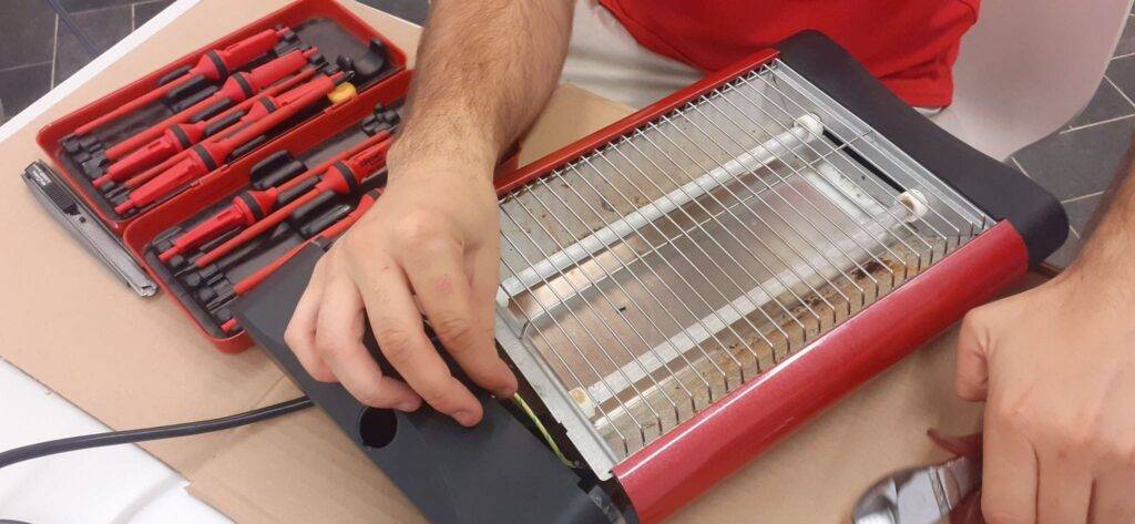 voluntario repara una tostadora en el repair cafe del centro civico de NouBarris Barcelona